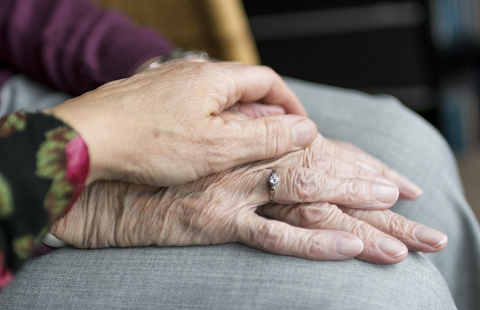 Two older people's hands on top of each other