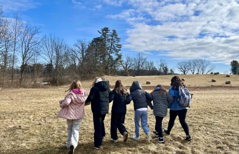 Girls walking in a field hand in hand