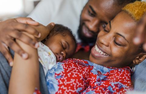 Young parents with their baby girl at home.