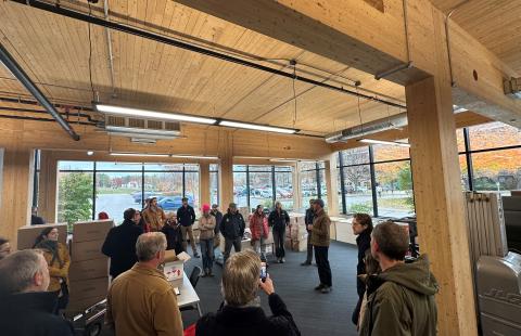 a group of participants standing in a building made of cross laminate timber