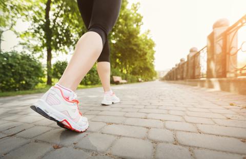 Woman walking in park from the legs down.
