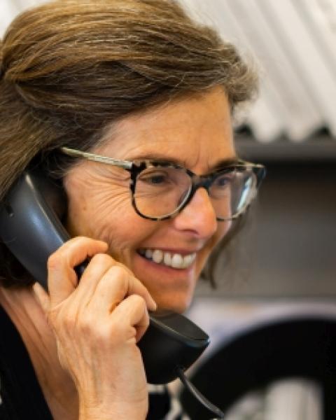 woman talking on the phone, for context with the UNH Infoline