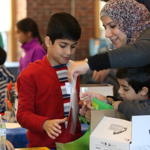Adult volunteer helping students with STEM project