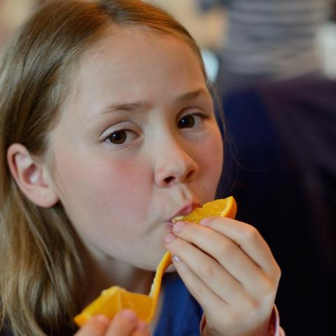 girl eating orange